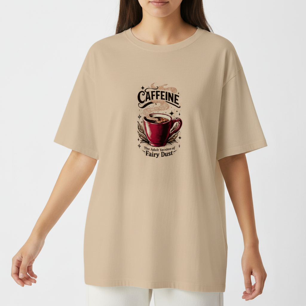 Camiseta com estampa frontal de uma xícara de café com vapor, rodeada por estrelas, a palavra "CAFFEINE" acima e a frase "The Adult Version of Fairy Dust" abaixo.