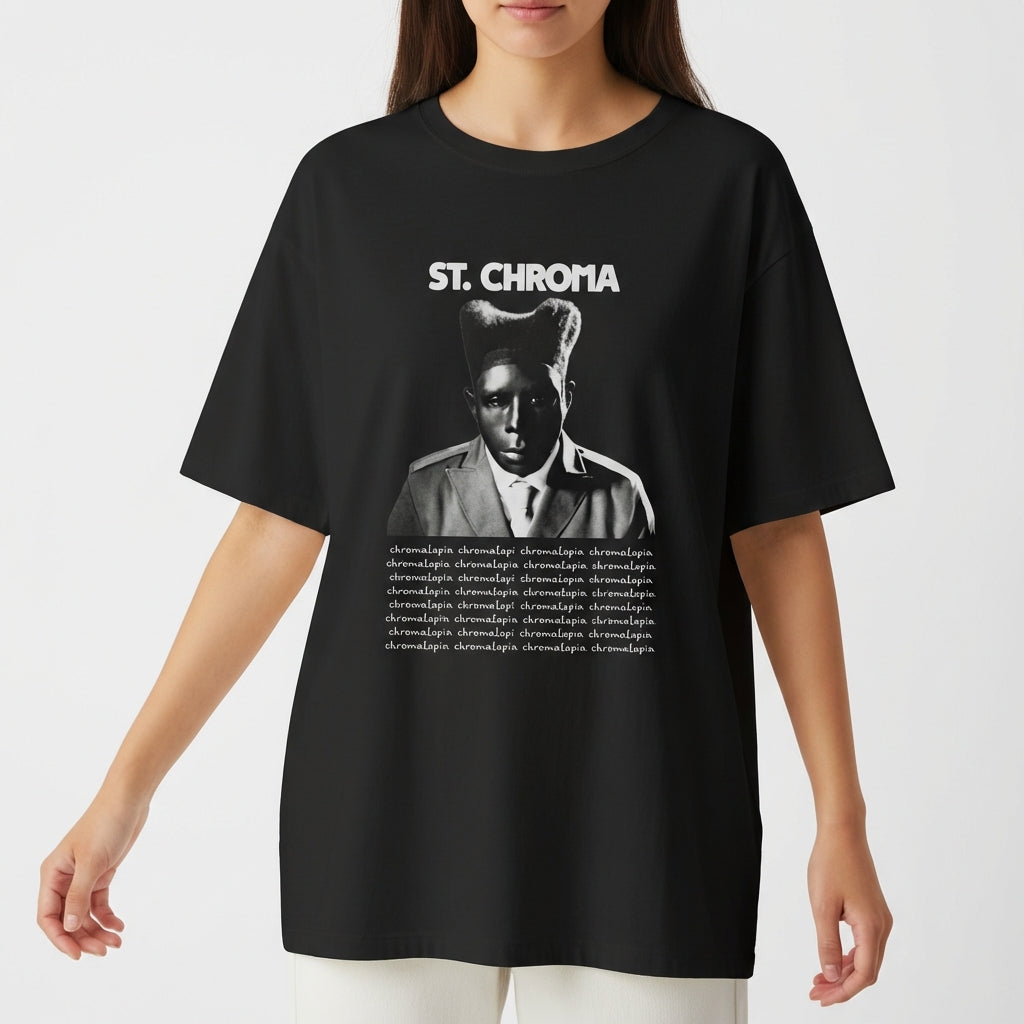 Camiseta com estampa frontal de retrato em preto e branco de pessoa usando chapéu, logo "St. Chroma" acima e texto repetido em linhas abaixo.