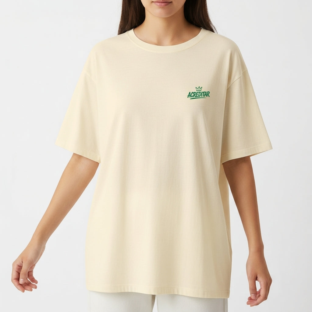 Camiseta com estampa frontal de pequena coroa e "ACREDITAR" estilizado, e estampa traseira de jogador com coroa, cores vibrantes e mensagem inspiradora.