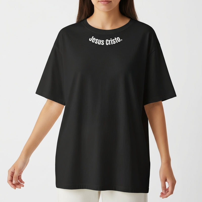 Camiseta com estampa frontal de "Jesus Cristo." em letras maiúsculas e brancas, centralizada próxima à gola, sem outros elementos gráficos.