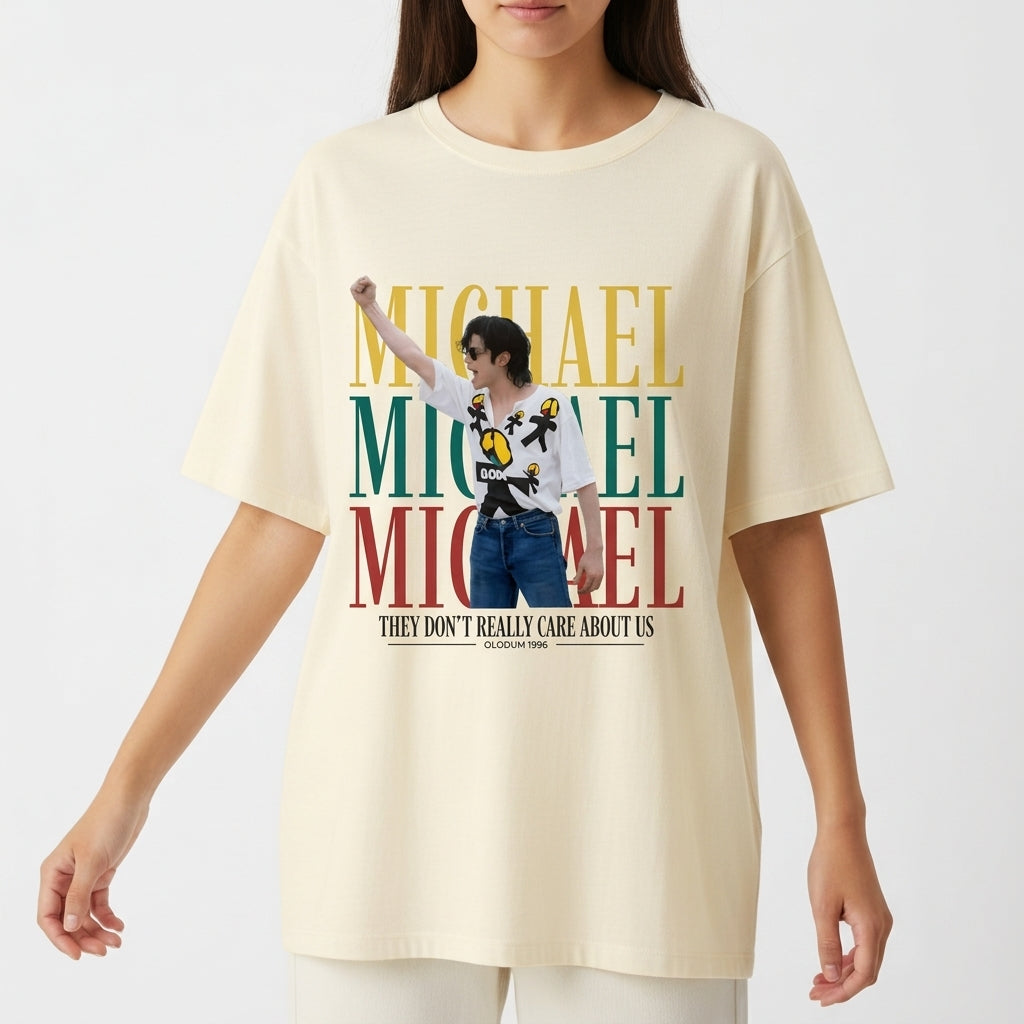 Camiseta com estampa frontal de figura central performática sobreposta a letras grandes em camadas, acima de frase estilizada na parte inferior.