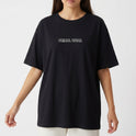 Camiseta com estampa frontal de logo "PRIMAL WEAR" e estampa traseira de tubarão humanizado sentado, cercado por água e elementos coloridos.