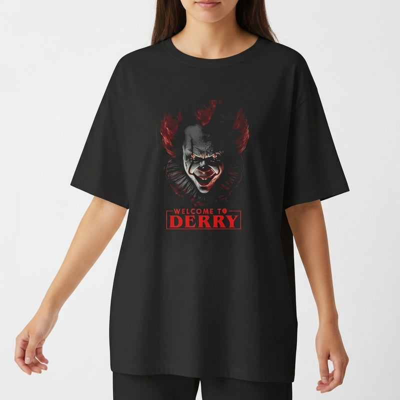 Camiseta com estampa frontal de rosto sombrio de palhaço em meio à escuridão com a frase "Welcome to Derry" em letras destacadas.
