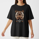 Camiseta com estampa frontal de figura com asas e mãos postas em pose de oração, cercada por elementos gráficos e texto em estilo gótico.