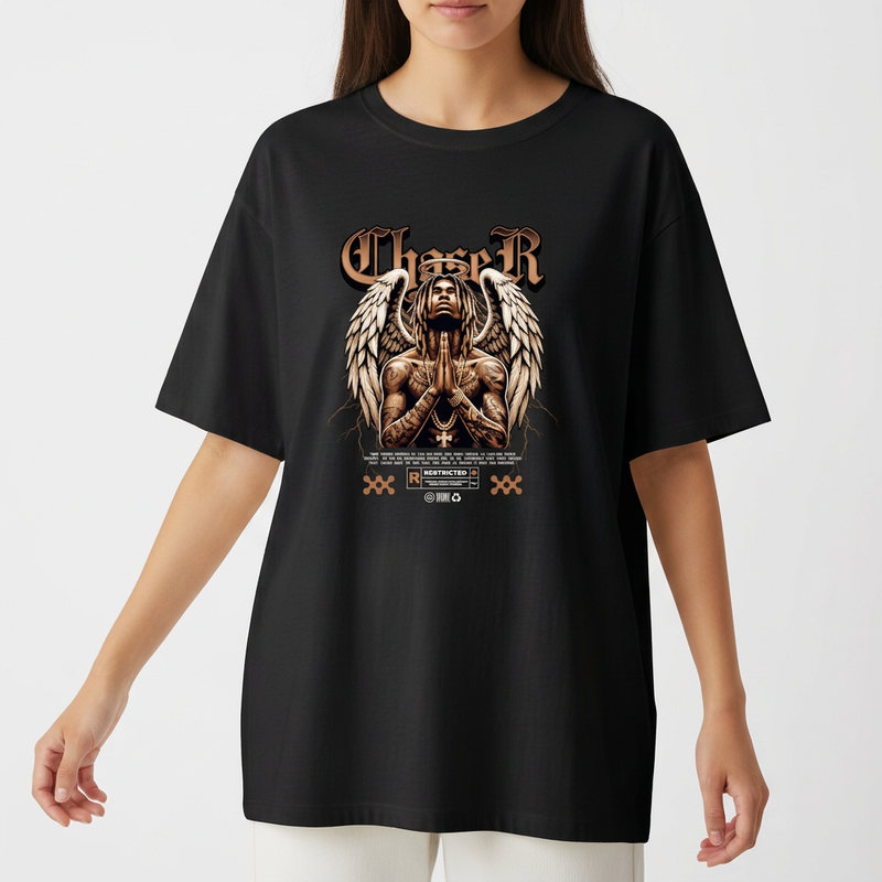 Camiseta com estampa frontal de figura com asas e mãos postas em pose de oração, cercada por elementos gráficos e texto em estilo gótico.