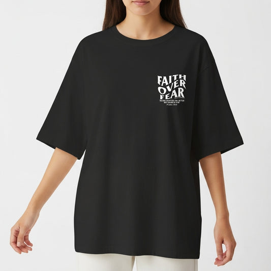 Camiseta com estampa frontal de "Faith Over Fear" com detalhes em texto pequeno e estampa traseira de "Faith Over Fear" acompanhada de citação extensa.