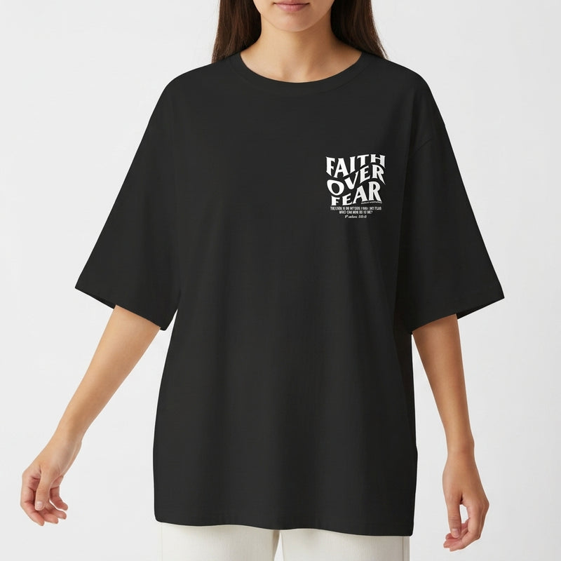 Camiseta com estampa frontal de "Faith Over Fear" com detalhes em texto pequeno e estampa traseira de "Faith Over Fear" acompanhada de citação extensa.