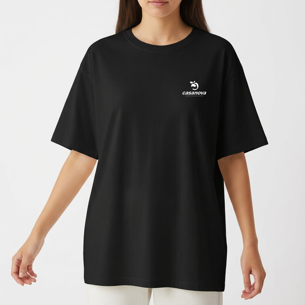 Camiseta com estampa frontal de logotipo discreto com texto pequeno e símbolo estilizado, e estampa traseira de pinguim surfando em onda com texto vibrante.