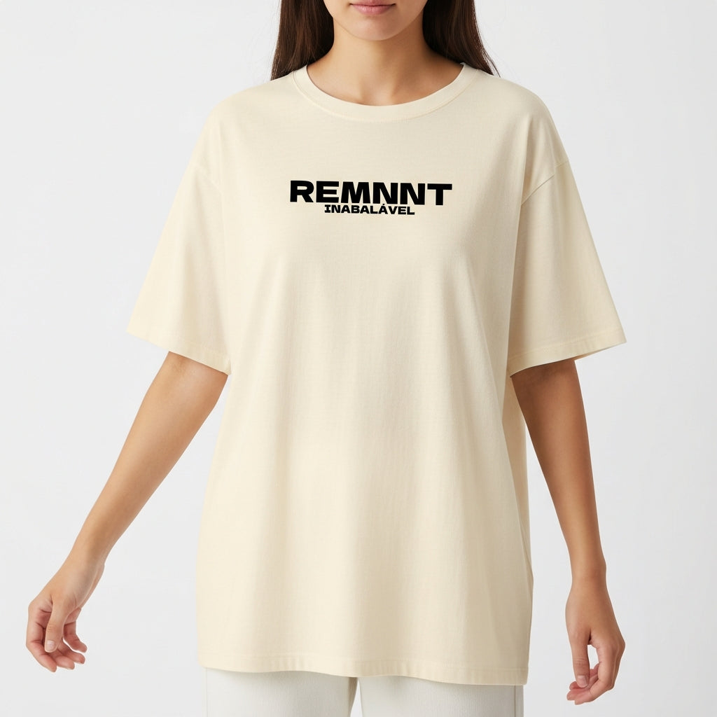 Camiseta com estampa frontal de texto estilizado "REMNNT" em letras maiúsculas e "IMBATÍVEL" em tamanho menor, alinhados centralmente.