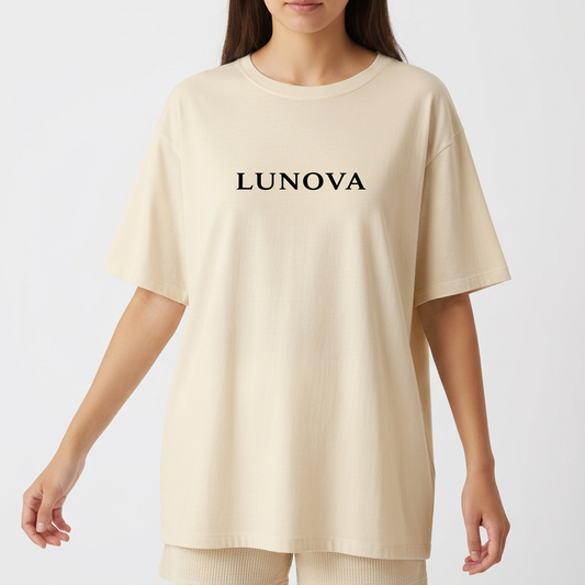 Camiseta com estampa frontal de "LUNOVA" em letras estilizadas e estampa traseira de um anjo em posição contemplativa sob o texto "ANJO" repetido acima.