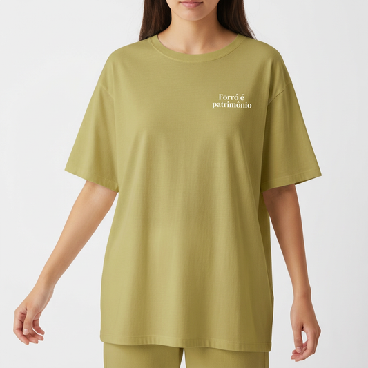 Camiseta com estampa frontal de texto "Forró é patrimônio" no lado superior esquerdo e estampa traseira de pequeno círculo ornamental no centro do colarinho.