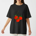 Camiseta com estampa frontal de três tomates brilhantes com hastes verdes, dispostos em um padrão artístico que realça detalhes visuais e cores vibrantes.