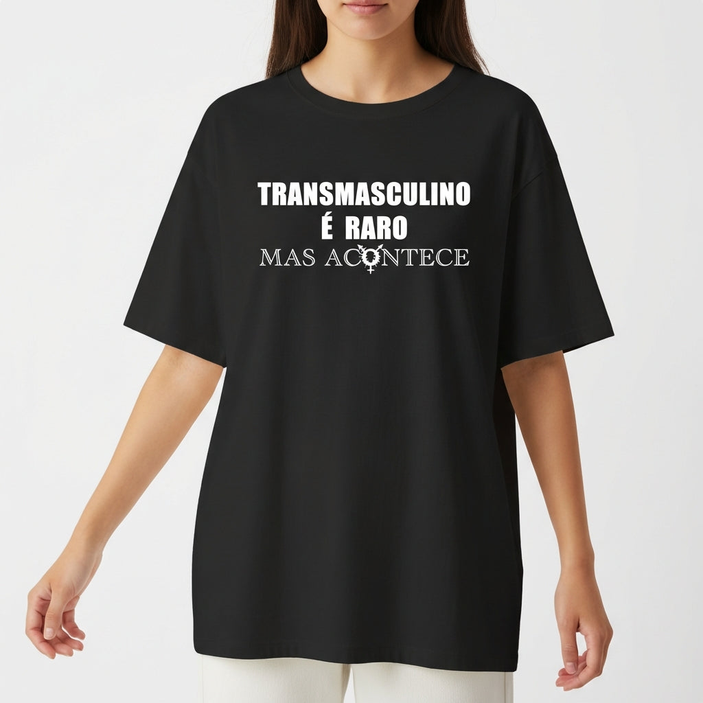 Camiseta com estampa frontal de texto "Transmasculino é raro mas acontece" e ícone; estampa traseira de gráfico circular com a palavra "TRANSVESTICO".