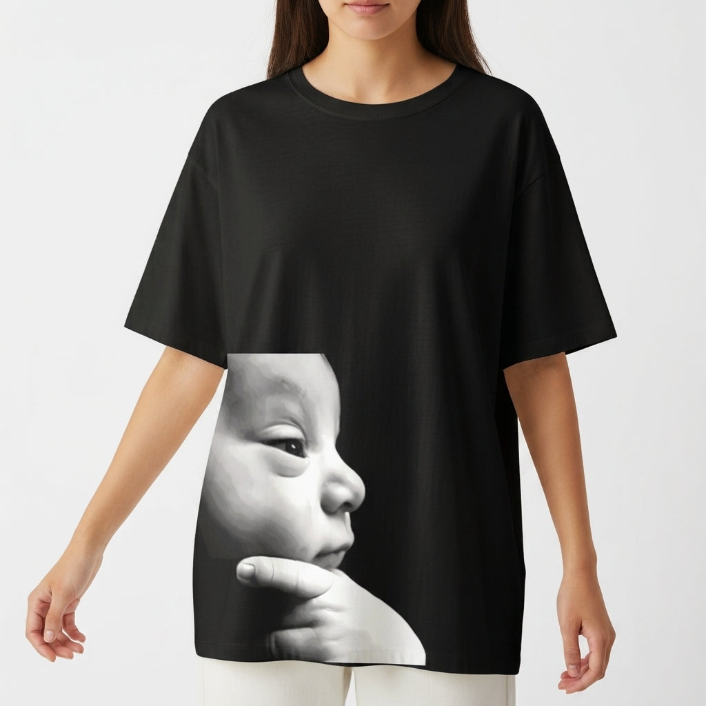 Camiseta com estampa frontal de rosto de bebê em perfil com expressão serena e dedos apoiados no queixo em estilo fotorrealista minimalista.