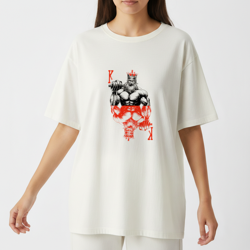 Camiseta com estampa frontal de um rei musculoso segurando um haltere, adornado com uma coroa e cercado por letras K estilizadas verticalmente.
