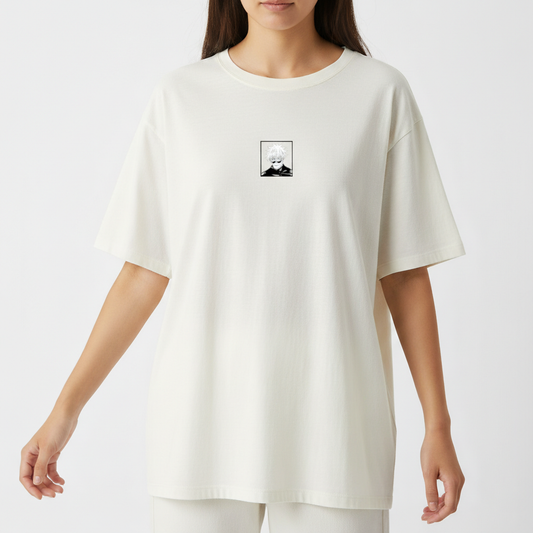 Camiseta com estampa frontal de um retrato em estilo desenho de personagem de cabelo claro e estampa traseira de olho azul rodeado por caracteres orientais.