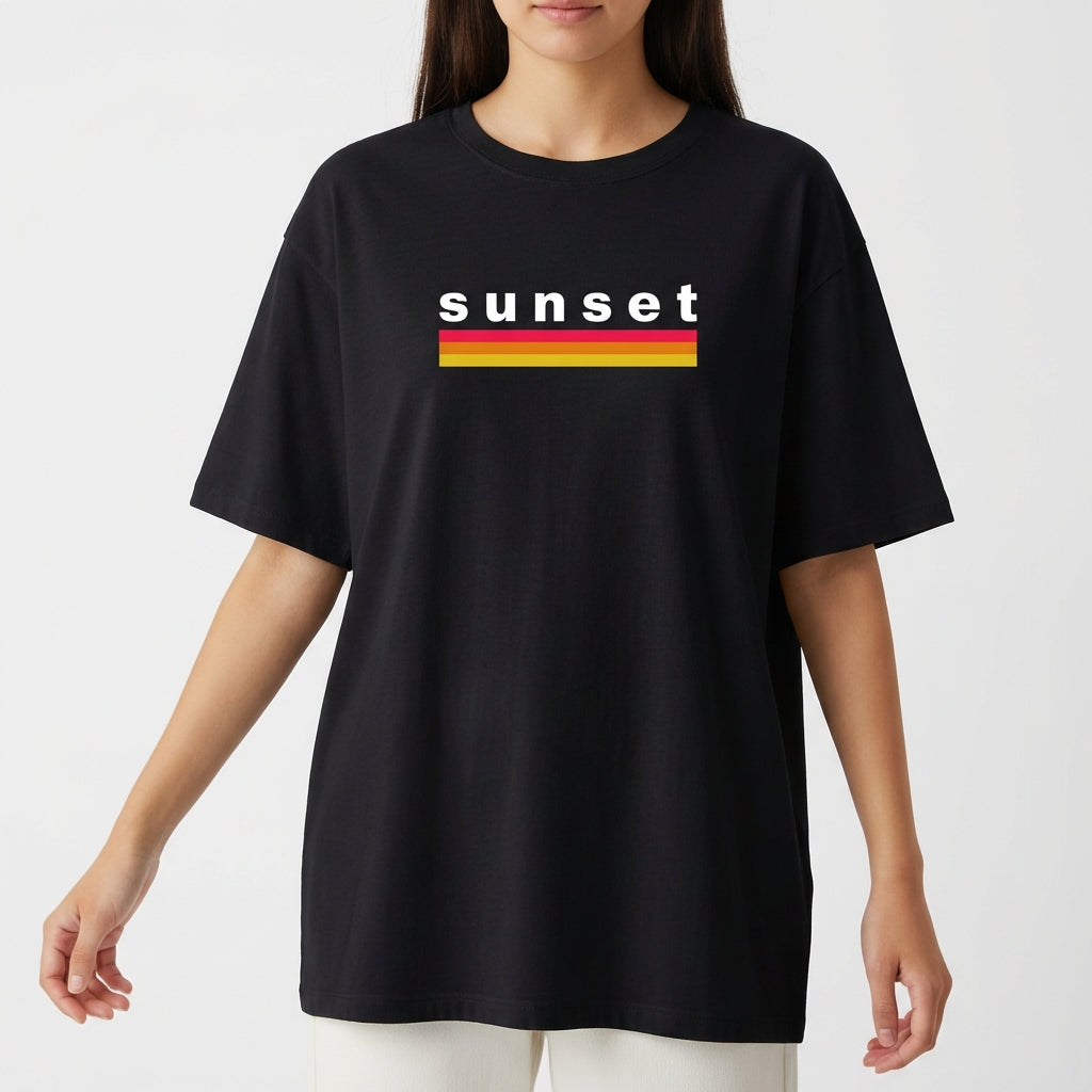 Camiseta com estampa frontal de texto "sunset" em letras minúsculas acima de duas listras horizontais, uma vermelha e outra amarela.