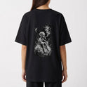 Camiseta com estampa traseira de alienígena sentado numa superfície rochosa, fumando com tranquilidade, envolto em uma atmosfera etérea e nebulosa sob a lua.