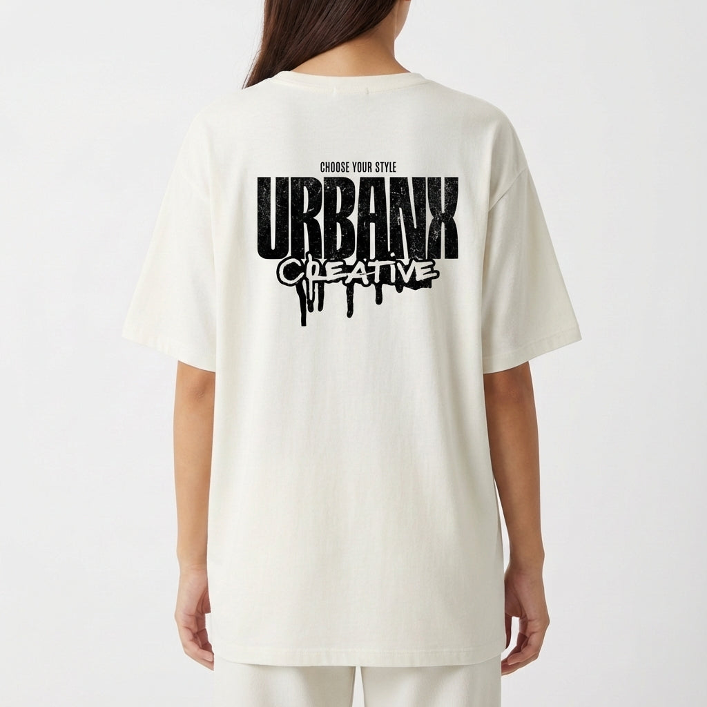 Camiseta com estampa frontal de texto vertical "URBANX" e estampa traseira de "CHOOSE YOUR STYLE URBANX CREATIVE" com letras grandes e efeito de tinta escorrendo.
