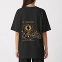 Camiseta com estampa frontal de design intrincado com elementos florais ao redor de texto e estampa traseira de figura mística centralizada com ornamentos detalhados.