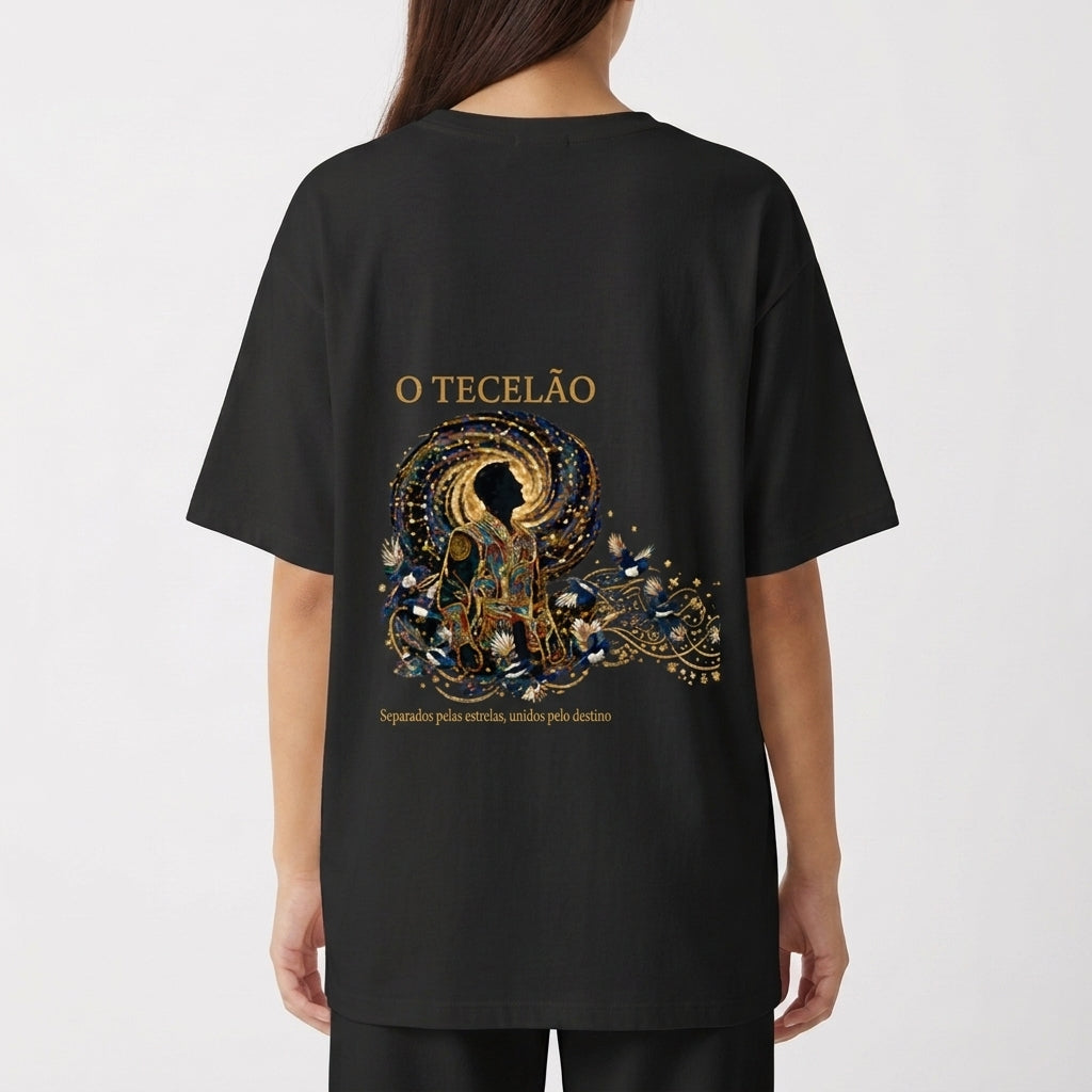 Camiseta com estampa frontal de design intrincado com elementos florais ao redor de texto e estampa traseira de figura mística centralizada com ornamentos detalhados.