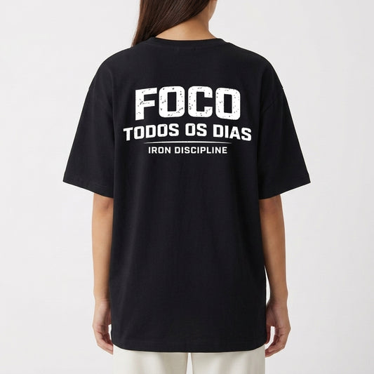 Camiseta com estampa frontal de texto “IRON DISCIPLINE” estilizado e, na estampa traseira, texto “FOCO TODOS OS DIAS” em negrito com “IRON DISCIPLINE”.