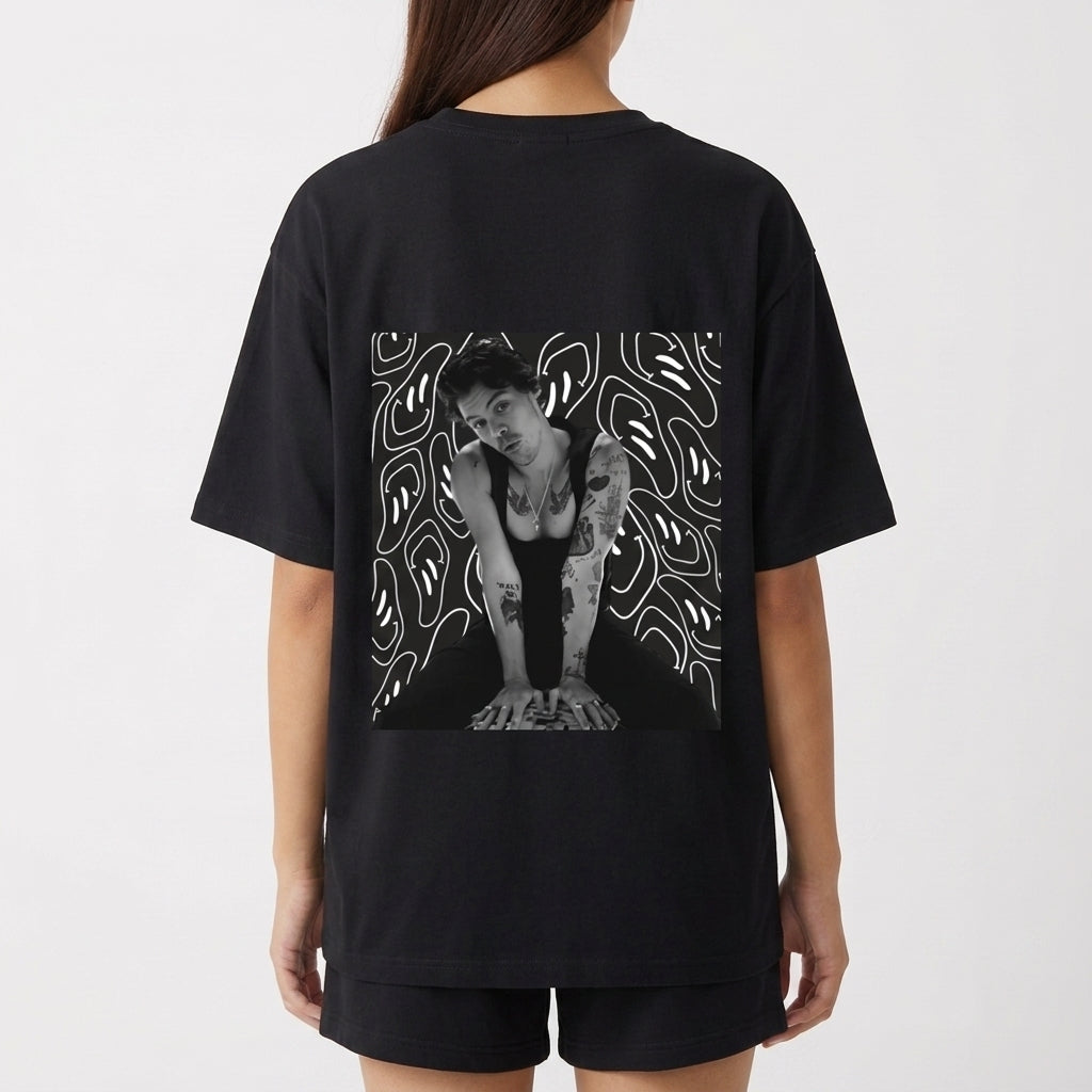 Camiseta com estampa frontal de linha irregular abstrata e estampa traseira de foto de uma pessoa sobre fundo com padrões de linhas fluidas.