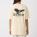 Camiseta com estampa frontal de águia detalhada, cercada por texto em círculo; e estampa traseira semelhante com águia maior, texto "Zoowear" e descrição adicional.