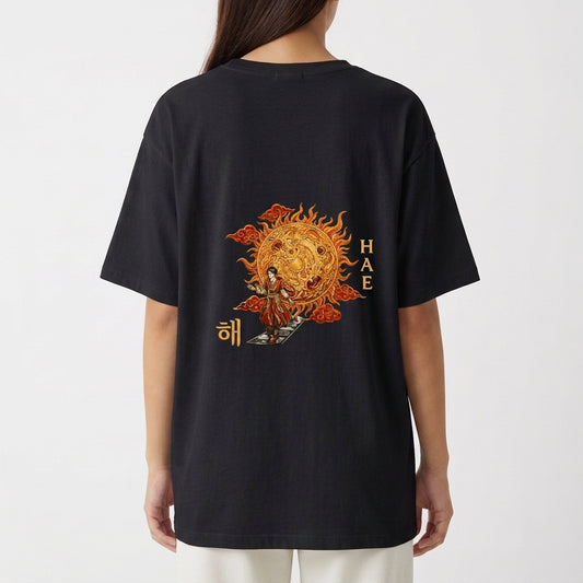 Camiseta com estampa frontal de um sol, um luar, montanhas e o texto "BECAME", e estampa traseira de um sol dourado decorado com símbolos orientais e figuras.