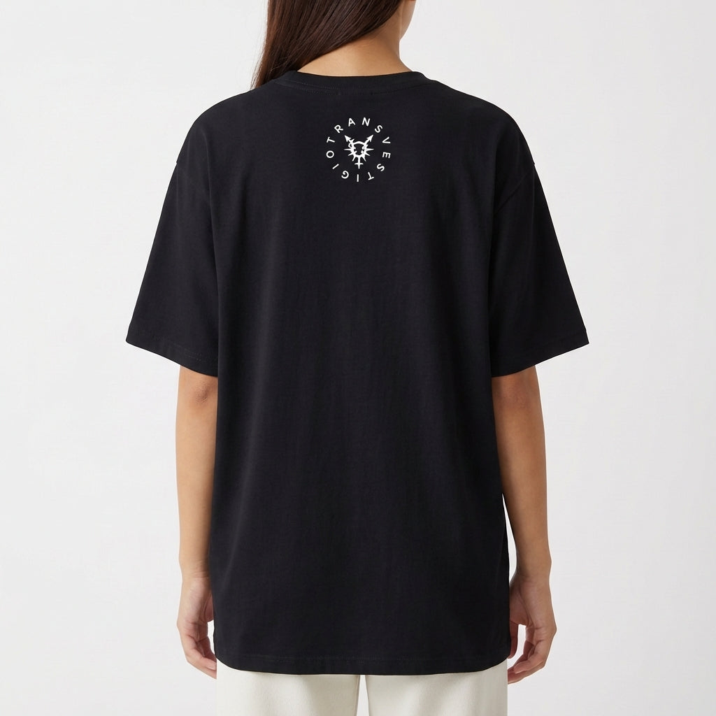 Camiseta com estampa frontal de texto "Transmasculino é raro mas acontece" e ícone; estampa traseira de gráfico circular com a palavra "TRANSVESTICO".
