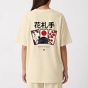 Camiseta com estampa frontal de escrita estilizada "Haganne" e estampa traseira com cartões de Hanafuda, garça, montanha e grafismos japoneses.