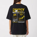 Camiseta com estampa frontal de duas mãos cruzadas segurando um controle de videogame e estampa traseira de design futurista com samurai e texto gráfico.