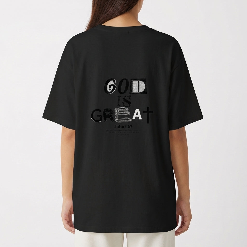 Camiseta com estampa traseira de palavras estilizadas e variadas fontes formando a frase "God is Great", acompanhada por uma referência bíblica ao versículo John 1:37.