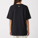 Camiseta com estampa frontal de texto "silêncio. o brasil tá jogando." com assinatura "FALAR, NÃO MURMURAR." e estampa traseira de "VERDELO" no topo.