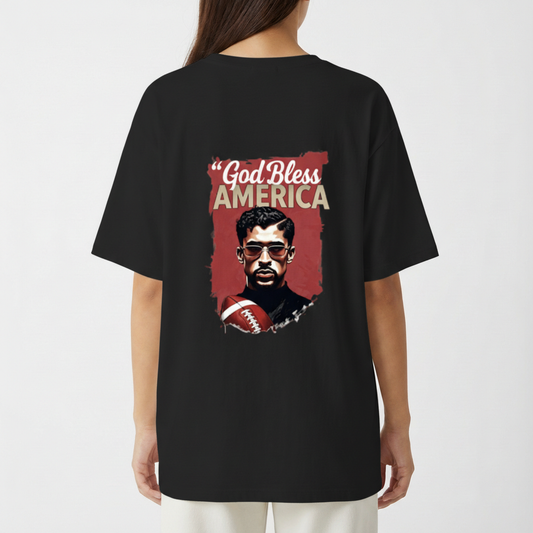 Camiseta com estampa frontal de texto "God Bless America Born 2000" e estampa traseira de ilustração de homem com óculos segurando bola de futebol americano.