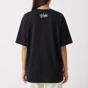 Camiseta com estampa frontal de "YESHUA" em letra destacada, acompanhada das palavras "HE SAVES" e símbolos abaixo; e estampa traseira de "Verbo Wear" elegantemente estilizada.