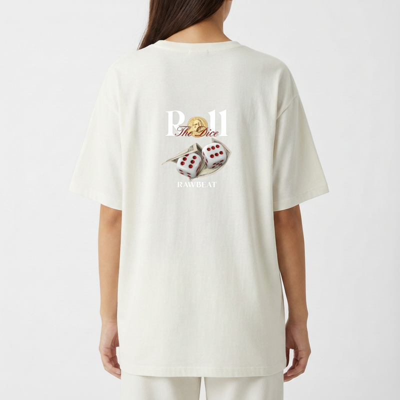 Camiseta com estampa traseira de dados sobre notas de dinheiro, texto estilizado "Roll The Dice", moeda ao fundo e a palavra "RAWBEAT" centralizada.