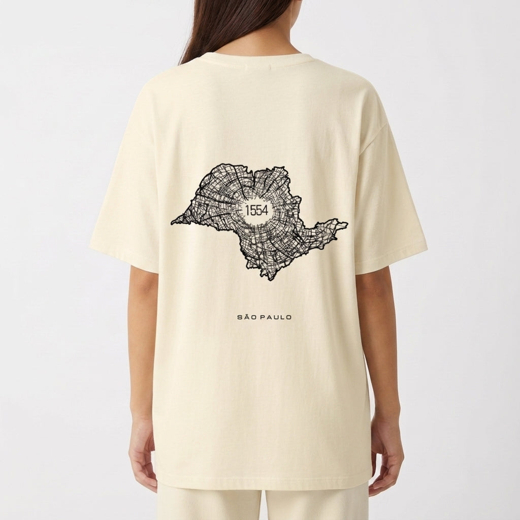 Camiseta com estampa frontal de texto vertical "A.SP.PAS" e estampa traseira de mapa em linhas com "1554" ao centro e "São Paulo" abaixo.