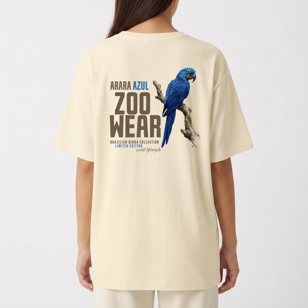 Camiseta com estampa frontal de arara azul em postura lateral com texto circular pequeno e estampa traseira de arara azul maior com texto "ZOOWEAR".