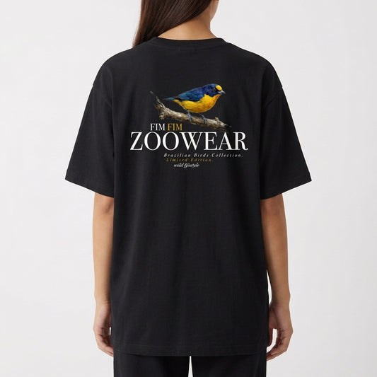 Camiseta com estampa frontal de uma ave colorida em galho, cercada por texto em arco, e estampa traseira de ave maior com texto destacado abaixo.