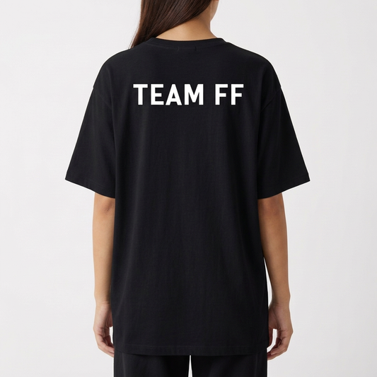Camiseta com estampa frontal de "T FF" estilizado e figura entre as letras e estampa traseira de "TEAM FF" em letras maiúsculas.