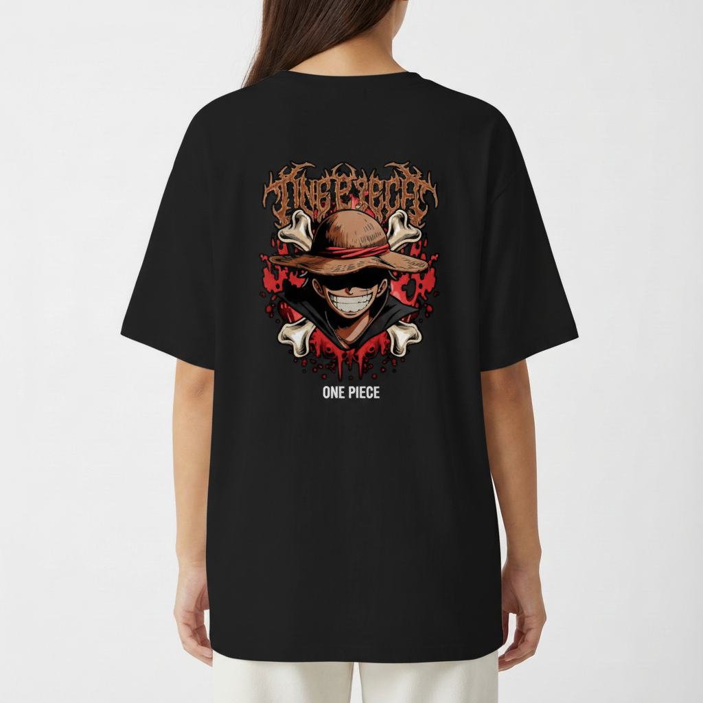 Camiseta com estampa frontal de personagem sorridente usando chapéu e estampa traseira de crânio estilizado cercado por ossos, malhas e texto gótico.