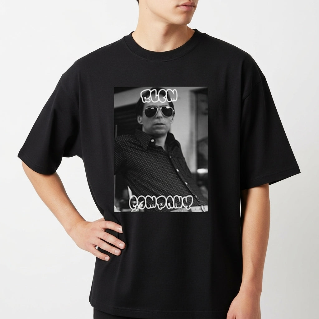 Camiseta com estampa frontal de fotografia em preto e branco de uma pessoa usando óculos escuros, com texto estilizado acima e abaixo da imagem.