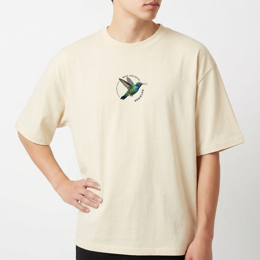 Camiseta com estampa frontal de beija-flor em voo circular e estampa traseira de beija-flor em destaque cercado por texto artístico estilizado.