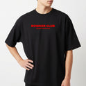 Camiseta com estampa frontal de "ROWKER CLUB" acima de "SPORT DIVISION" e estampa traseira de três globos sobre "ROWKER CLUB" e "SPORT DIVISION".