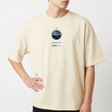 Camiseta com estampa frontal de um emblema circular contendo uma estrela acima, um padrão de linhas e montanhas, acompanhada de texto estilizado abaixo.