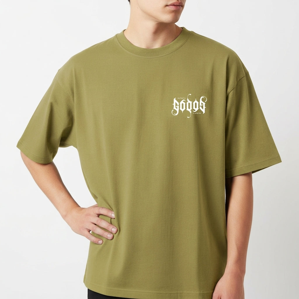 Camiseta com estampa frontal de texto estilizado em letras góticas com frase "my lord is" e estampa traseira maior replicando o mesmo texto.