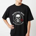 Camiseta com estampa frontal de uma caveira centralizada, cercada por arame farpado e acompanhada de uma rosa e as palavras “Memento Mori” acima e abaixo.