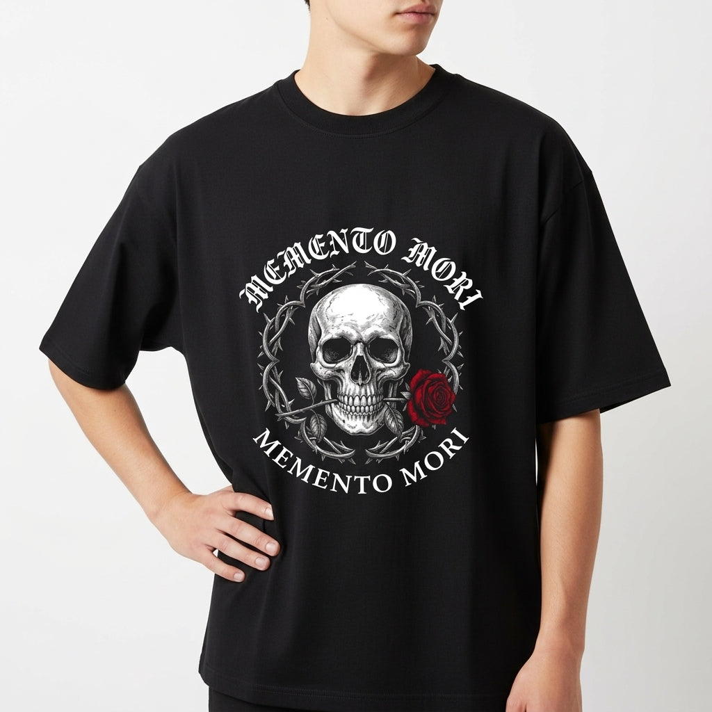 Camiseta com estampa frontal de uma caveira centralizada, cercada por arame farpado e acompanhada de uma rosa e as palavras “Memento Mori” acima e abaixo.