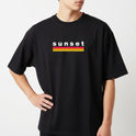 Camiseta com estampa frontal de texto "sunset" em letras minúsculas acima de duas listras horizontais, uma vermelha e outra amarela.